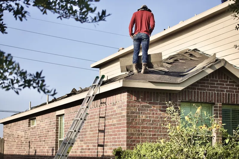 Professional roofer working on a residential roof in Kipling